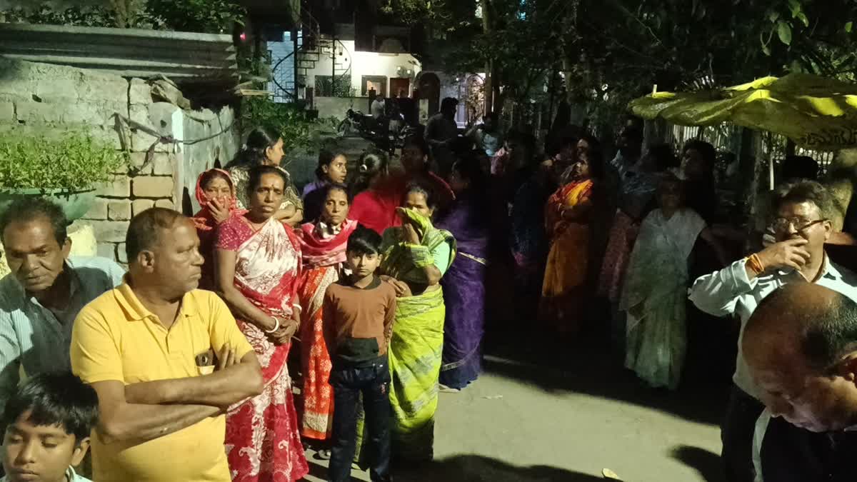 Locals gather outside the house where a man died by suspected suicide