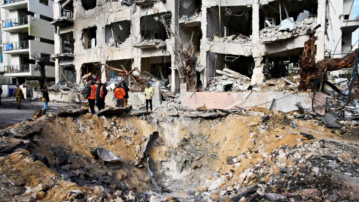 Rescue workers and military personnel survey the scene of a direct hit a day after an Iranian missile struck in Tel Aviv, Israel, Sunday (AP)