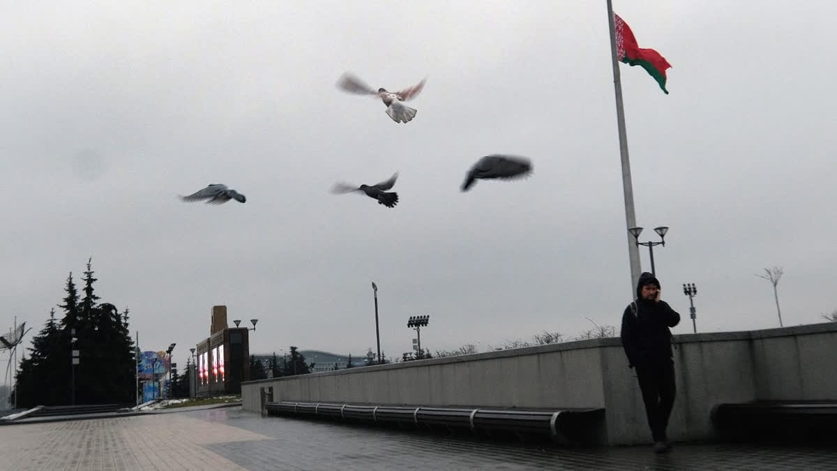 A man speaks on his mobile phone as he walks past the Belarus flag at half mast during a day of mourning for the victims off a Russian military plane crash over the Black Sea, on December 26, 2016 in Minsk.