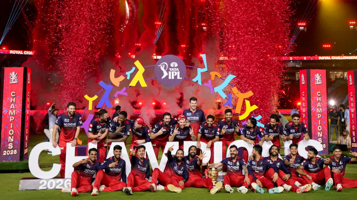 Royal Challengers Bengaluru's players celebrate with the tournament trophy during the presentation ceremony.