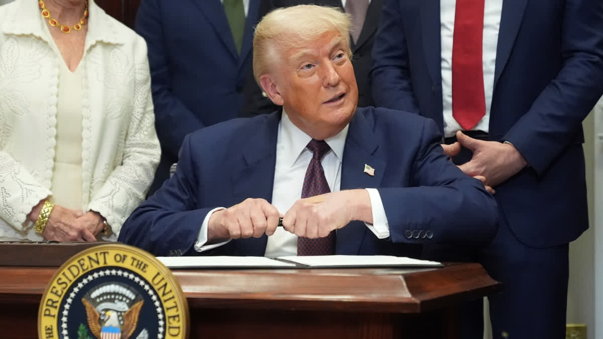 President Donald Trump signs an executive order restarting the Presidential Fitness Test in public schools, Thursday, July 31, 2025, in the Roosevelt Room of the White House in Washington.