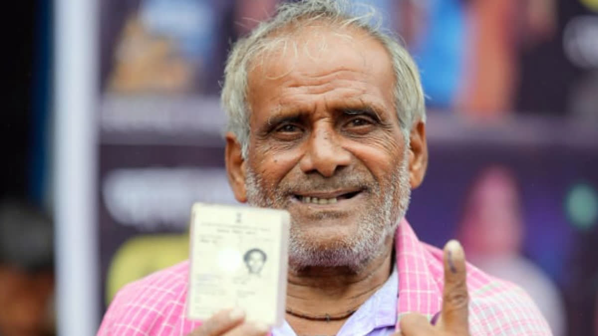 An elderly voter shows his inked finger