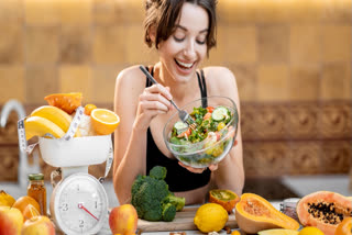 Woman eating a vegetarian salad and fruit