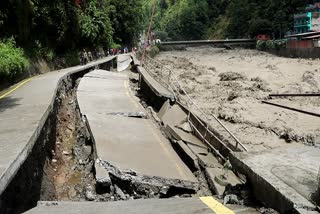 A view of a collapsed road alongside a swollen, muddy river following continuous heavy rainfall and floods, in Myagdi in Nepal.