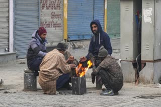 A group of men warm themselves on a cold winter day on Sunday, November 30, 2025
