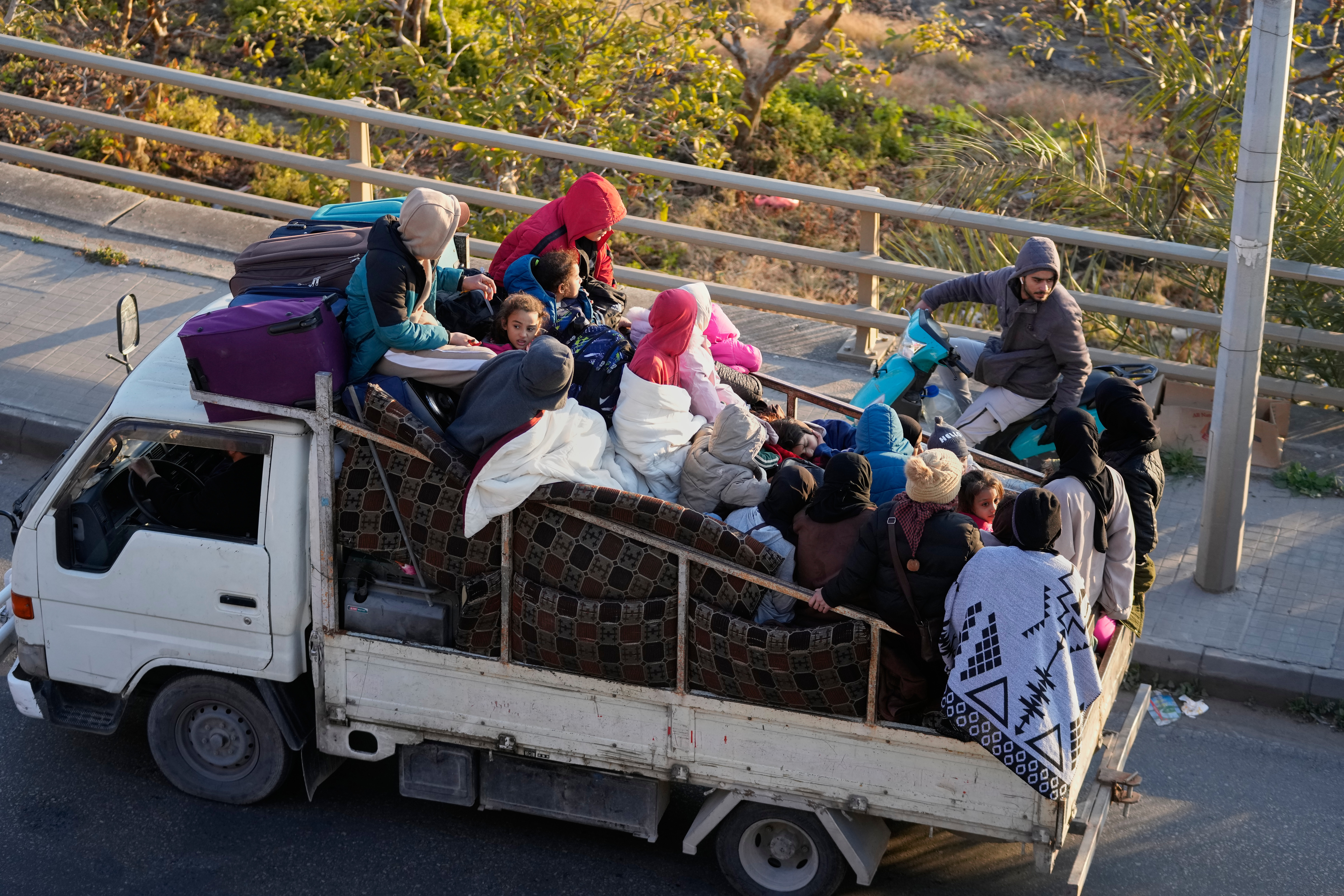 Displaced people fleeing Israeli strikes in southern Lebanon sits on a mini truck arrive in the southern port city of Sidon, early Monday, March 2, 2026