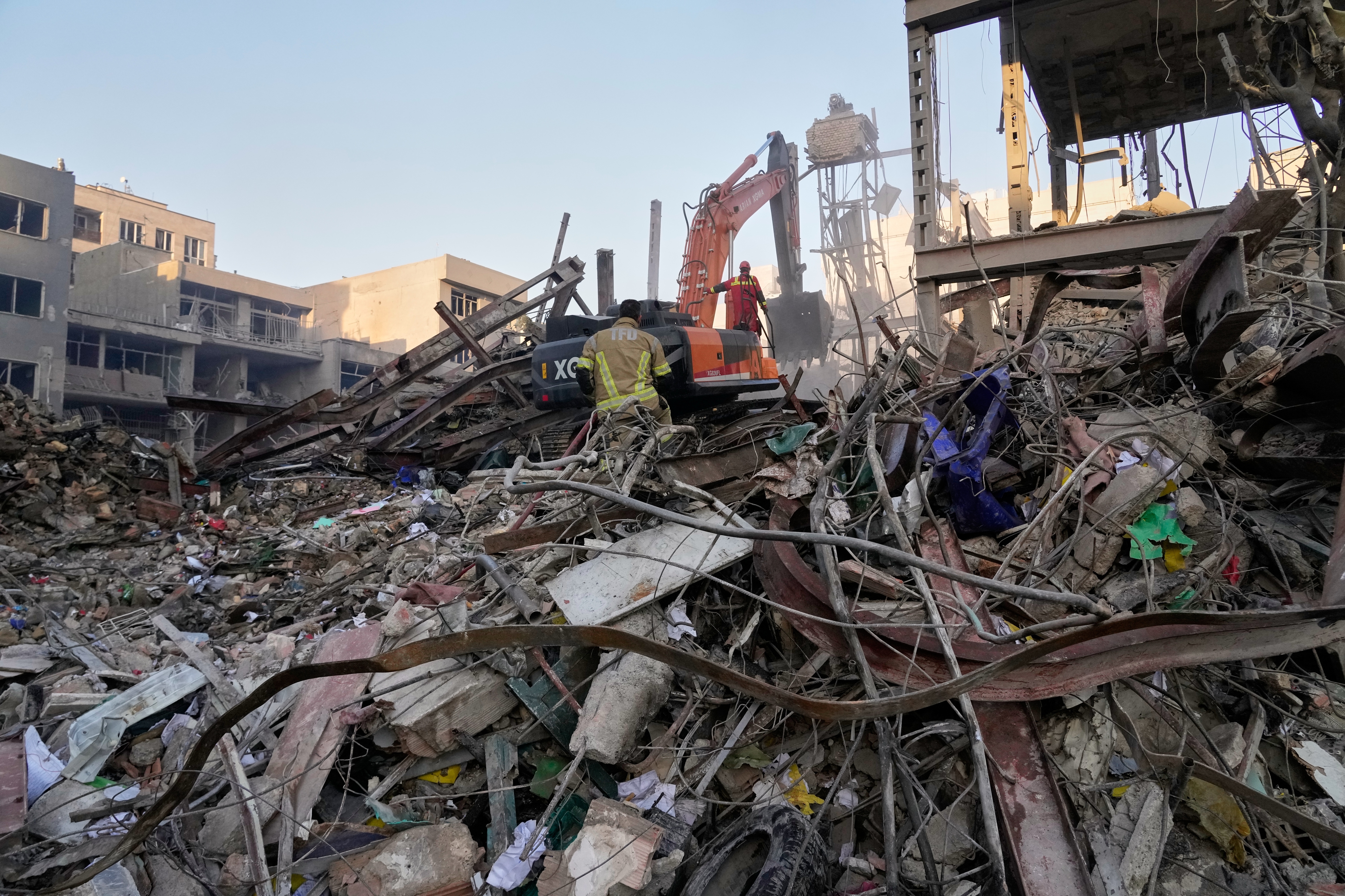 Civil defence workers survey the rubble