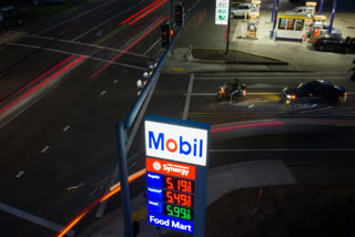 In this photo taken with a slow shutter speed, traffic moves past a sign for a Mobil gas station on Wednesday, April 29, 2026, in Portland, Ore.