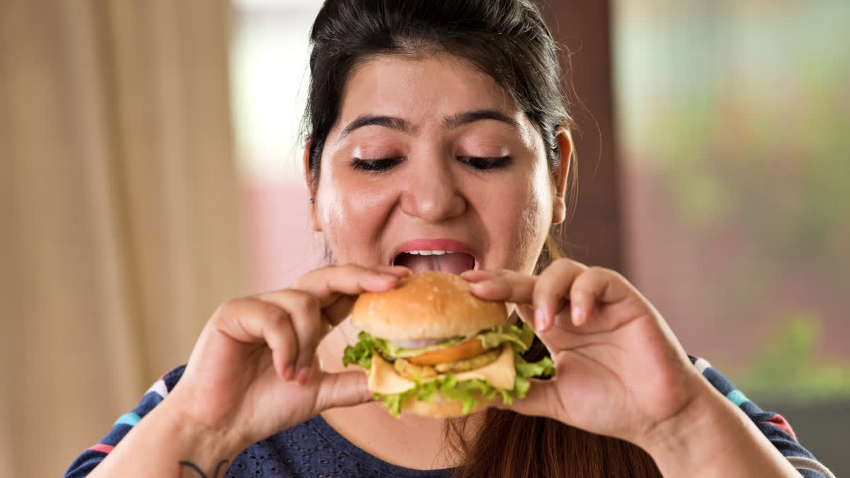 Teenage girl eating a burger