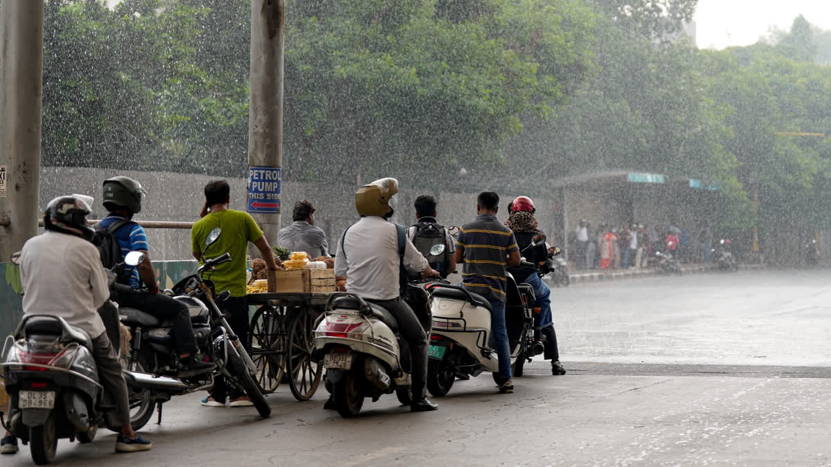 People take shelter under a foot over bridge amid rainfall, at Mathura Road in New Delhi on Wednesday, September 2, 2026.