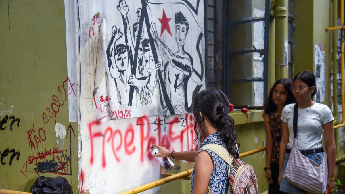 A file photo of members of Left-wing student organisations rewrite slogans on a wall at Jadavpur University after earlier controversial slogans and graffiti were erased.