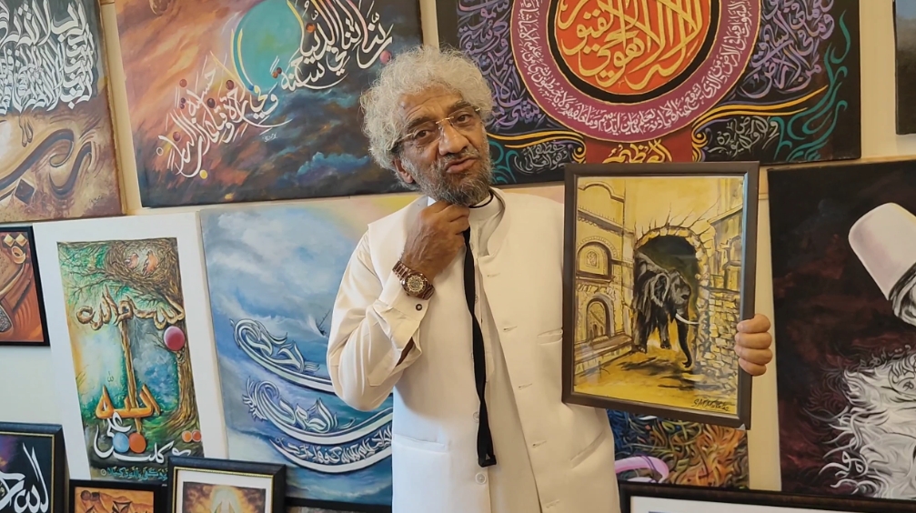 Painter SM Mushtaq shows a portrait at his art gallery in Srinagar, Jammu and Kashmir