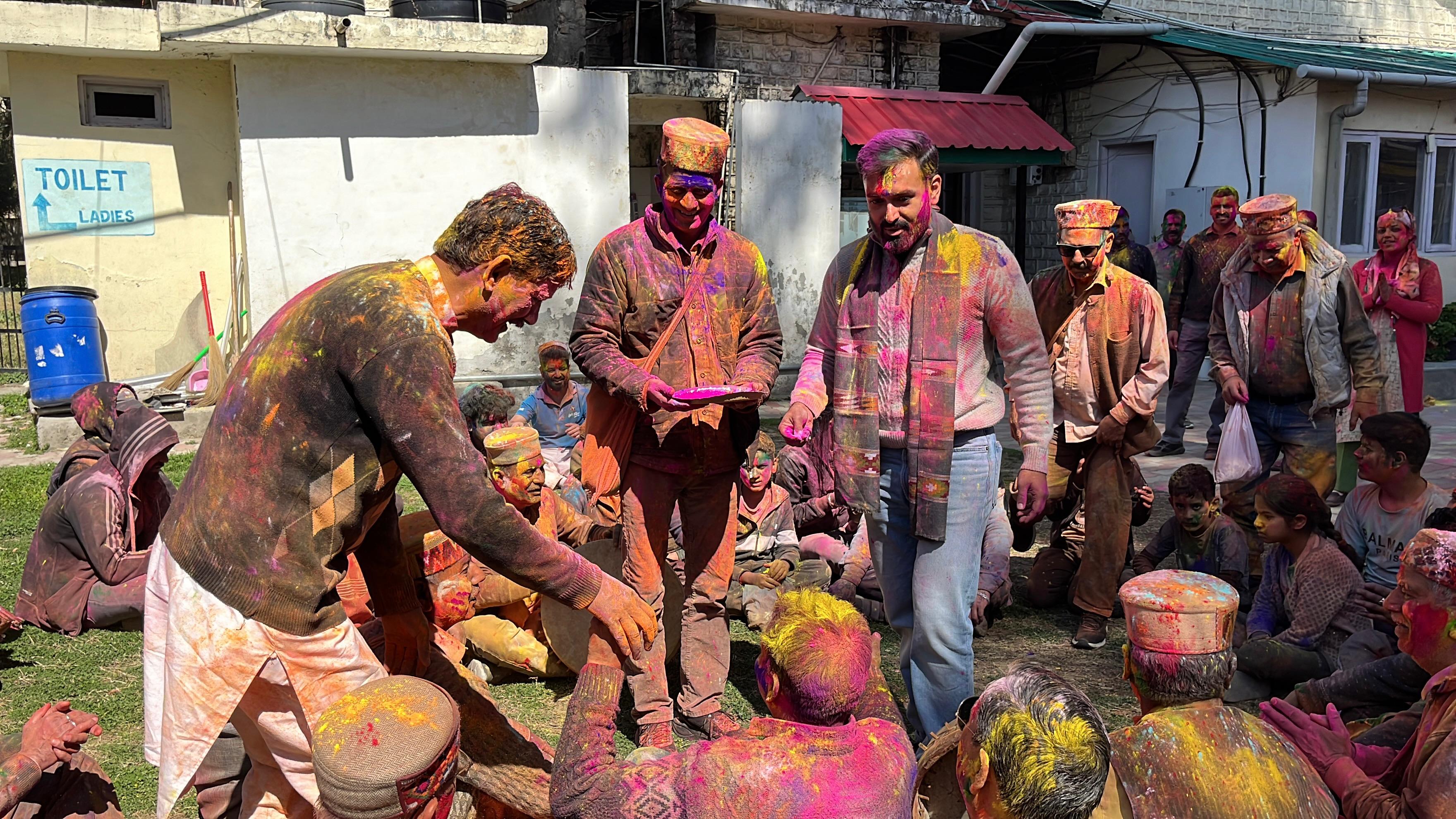 एक दूसरे को रंग लगाते लोग