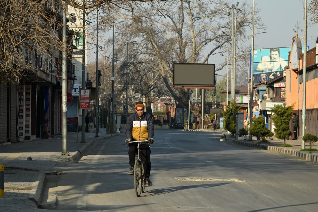 A man cycles in Srinagar amid curbs to foil Shia protests against Ayatollah Khamenei assassination