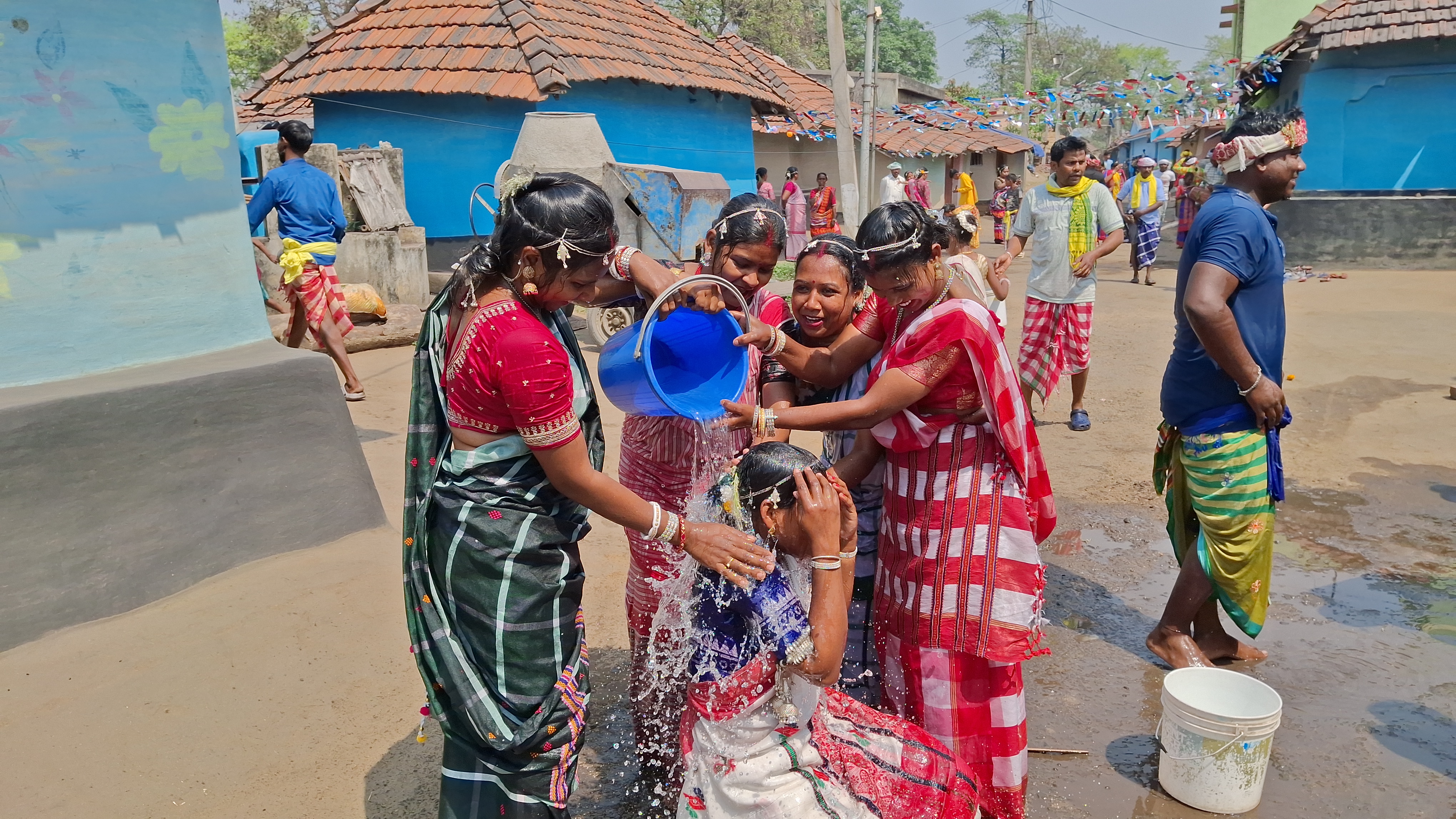 Women pour water on a fellow woman in Haramdihi village