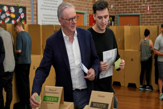 Australian Prime Minister Anthony Albanese and his son Nathan place their votes in a ballot box at a polling booth in his electorate in Sydney, Saturday, May 3, 2025.