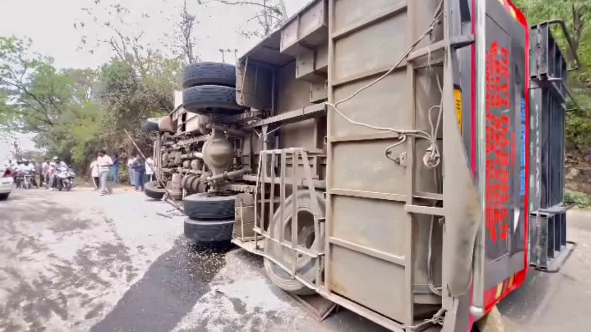 Locals gather near the overturned bus in Nurpur in Himachal Pradesh