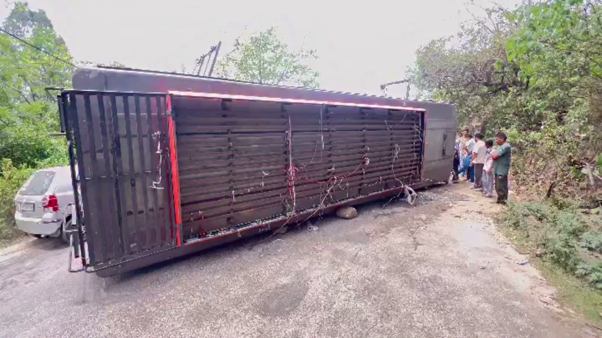 Locals gather near the overturned bus in Nurpur in Himachal Pradesh