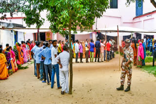People stand in queue outside polling booth to cast their votes