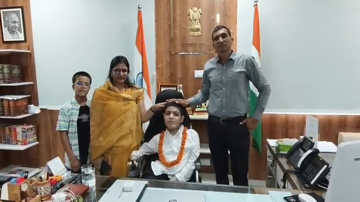 Proudly seated in the Collector's chair, with parents standing nearby.