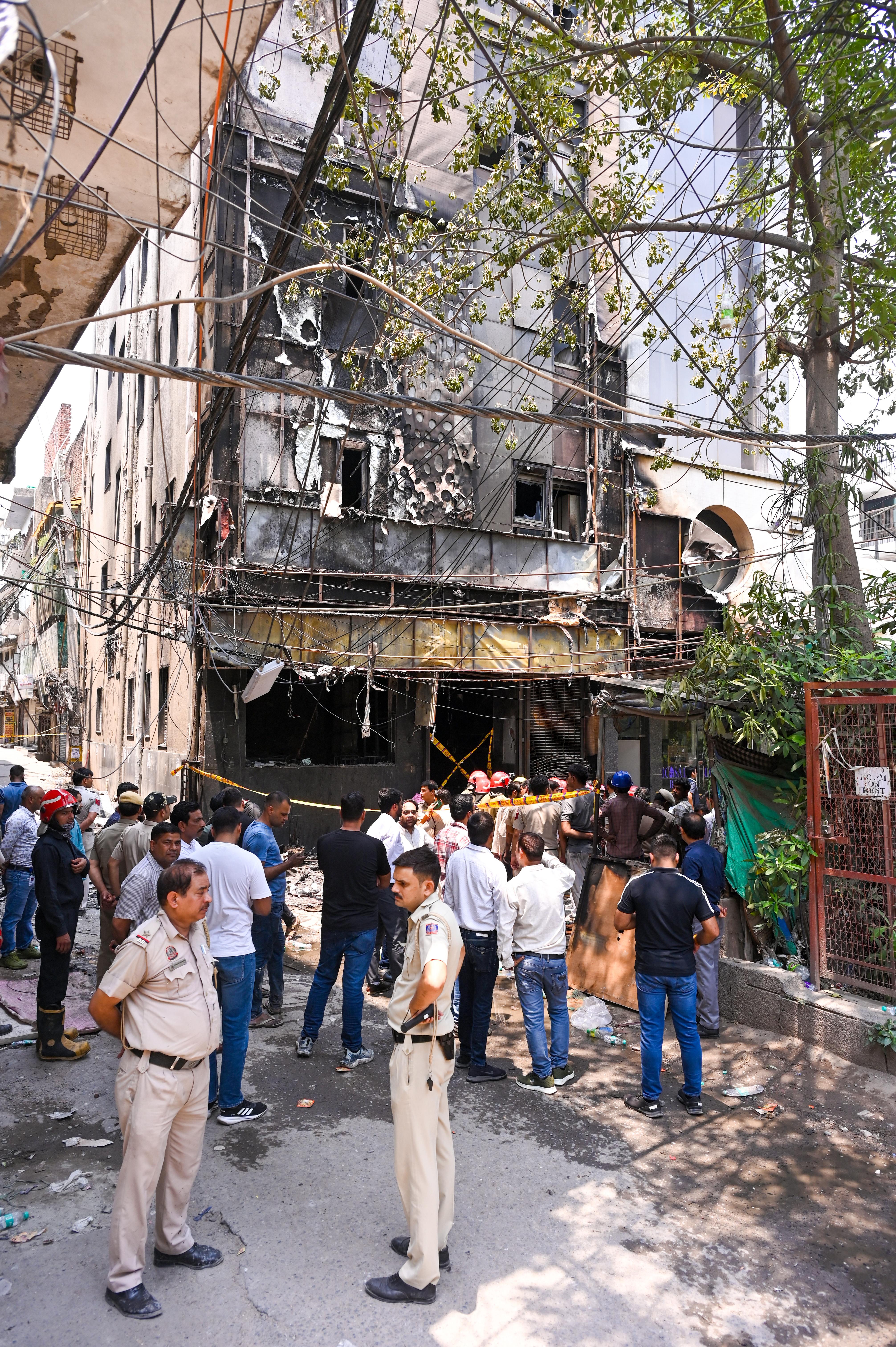 Police and fire officials inspect the charred building following the devastating fire.