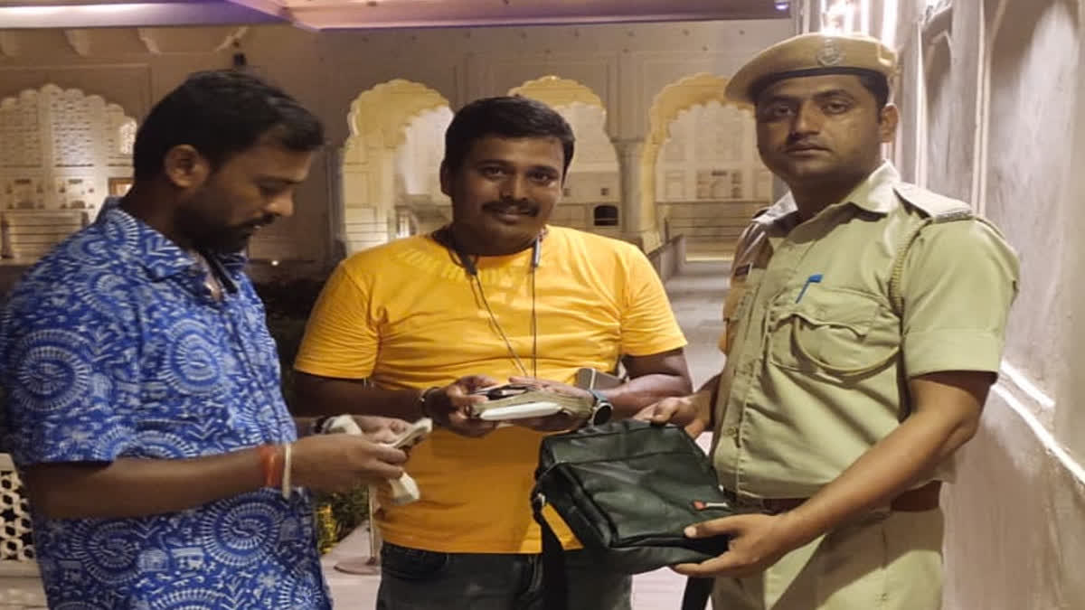 Amer Fort Home Guard Faisal Khan returning a bag to a tourist.