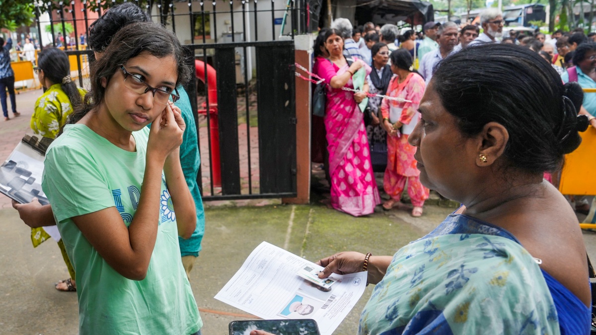 A National Eligibility Entrance Test (NEET PG) aspirant removes her earrings amid security checking before entering an examination centre, at Salt Lake, in Kolkata, Sunday, Aug. 3, 2025.