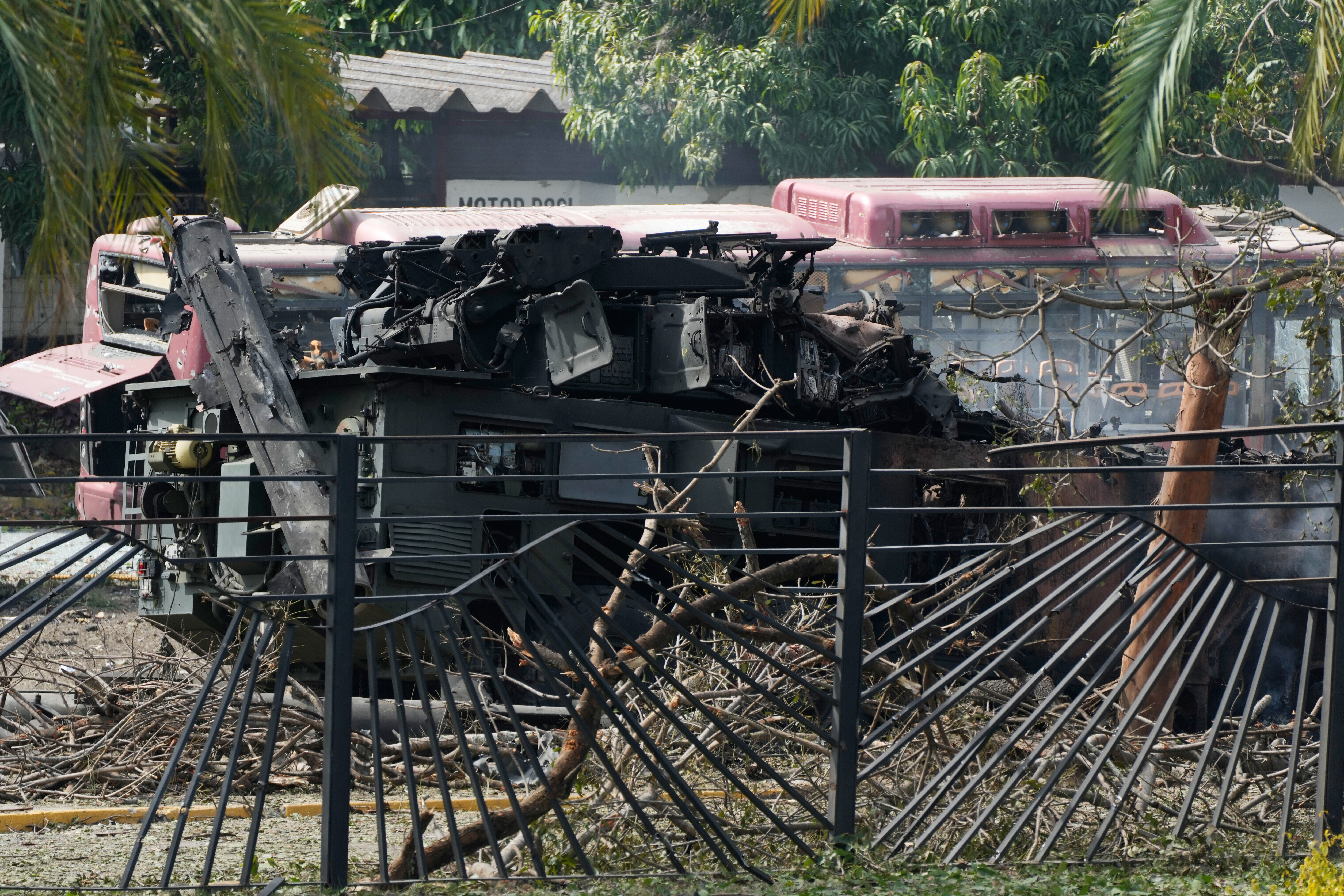 A destroyed armored vehicle sits at La Carlota airport in Caracas, Venezuela, Saturday.