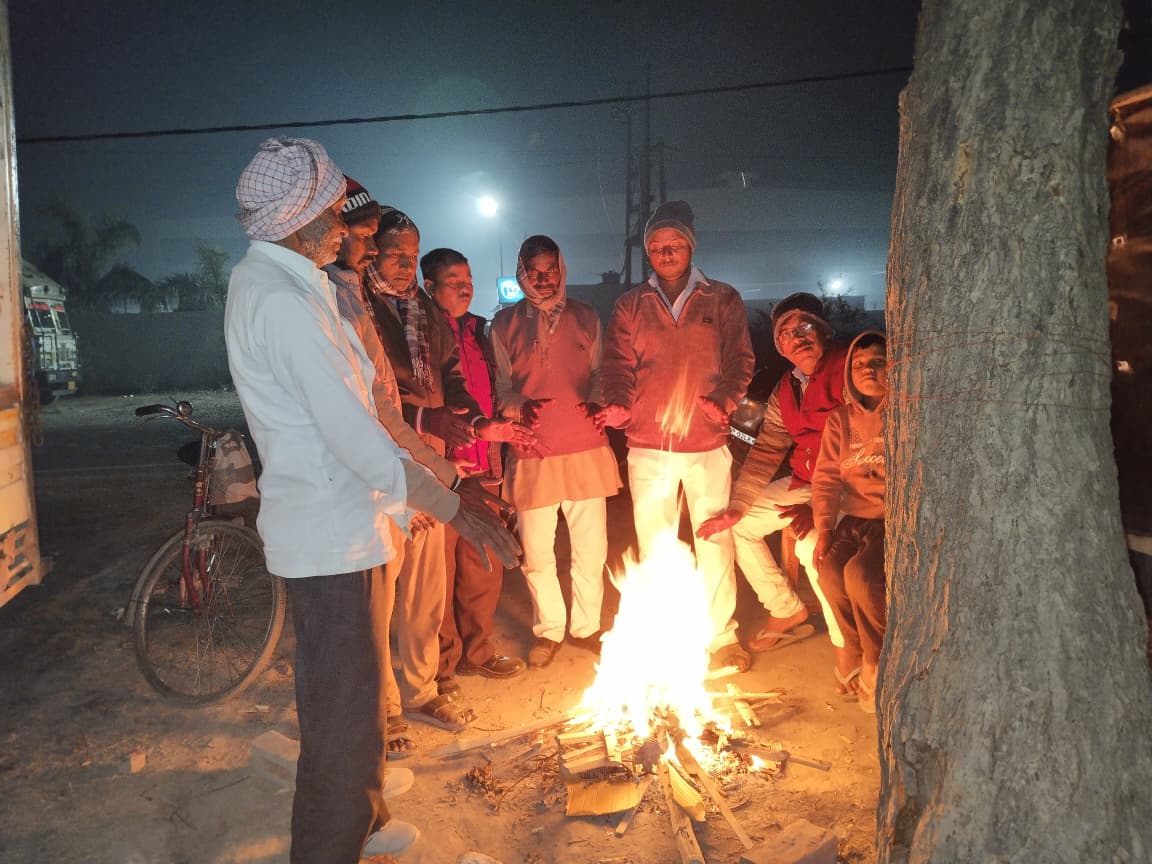 ठंड से बचने के लिए अलाव तापते लोग.