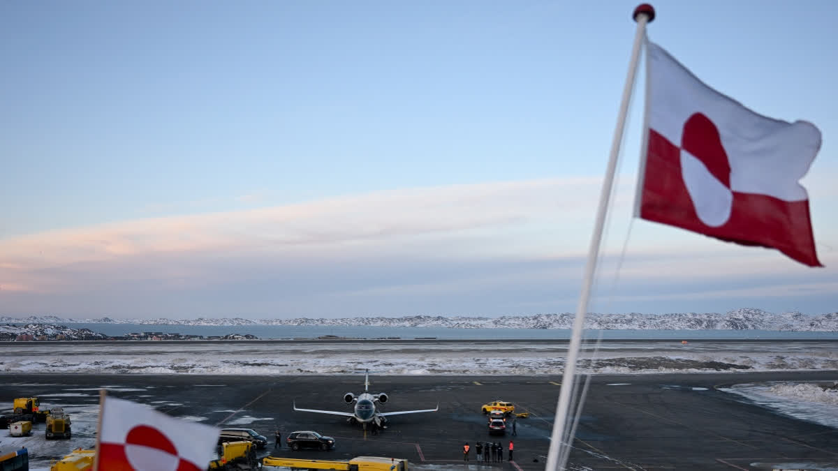 Greenlandic flags flutter in the wind as the airplane of Danish Prime Minister Mette Frederiksen stands at the airport in Nuuk, Greenland, on January 23, 2026.