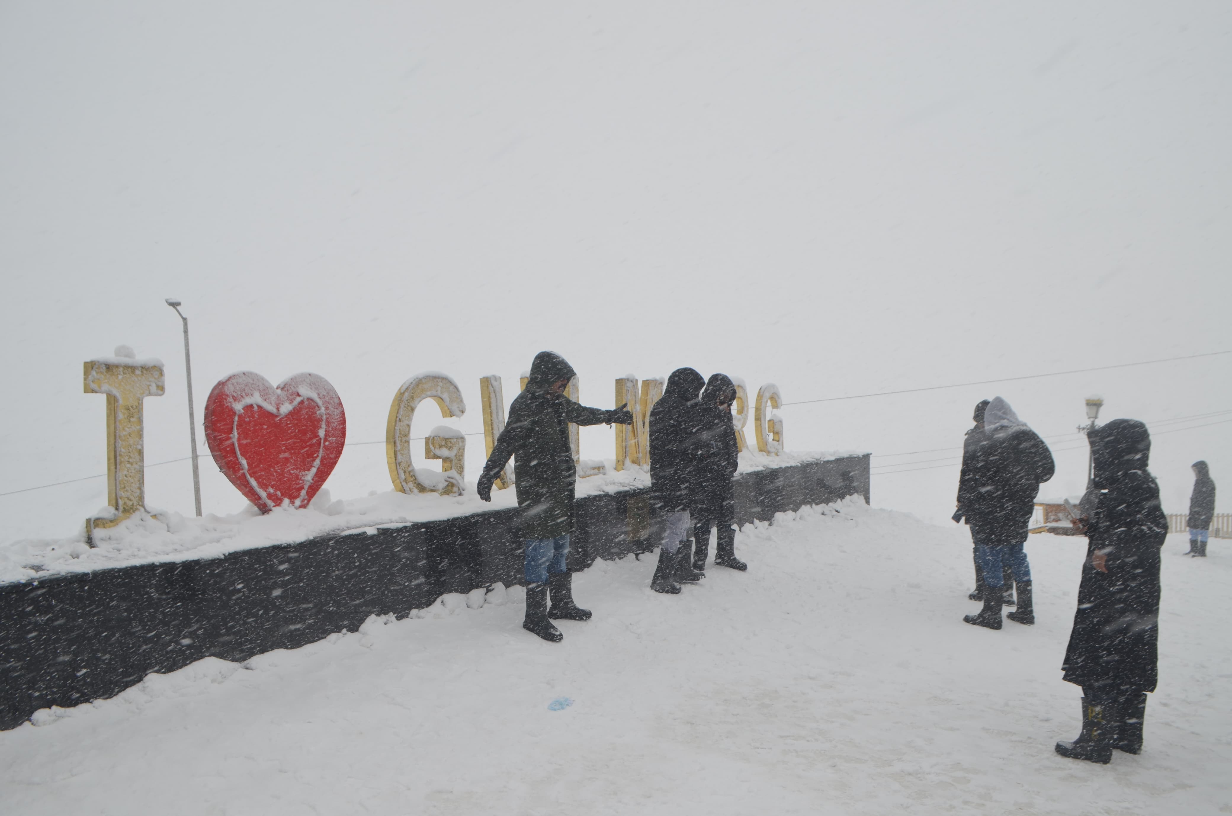 Tourists take photographs at snow clad Gulmarg
