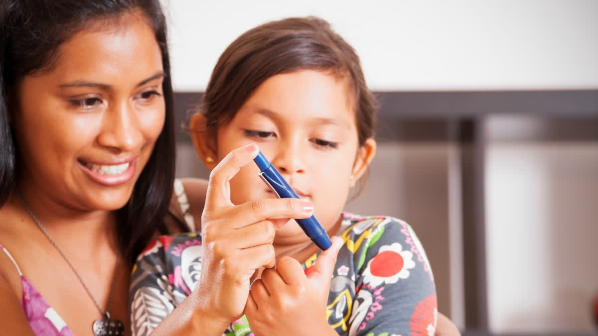A young girl checks her blood sugar with a diabetic pen