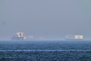 A tanker, left, and a car carrier are anchored at sea in the Gulf of Oman near the Strait of Hormuz, as seen from the coast near Khor Fakkan, United Arab Emirates, Friday, May 1, 2026.