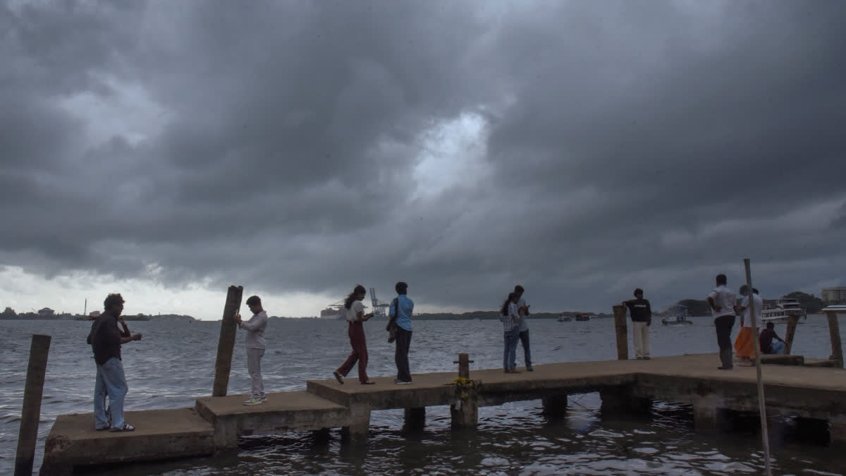 Visitors at the Marine Drive on a rainy afternoon, in Kochi