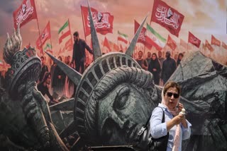 An Iranian woman walks past an anti-US billboard at Enghelab Square in central Tehran on August 3, 2026.