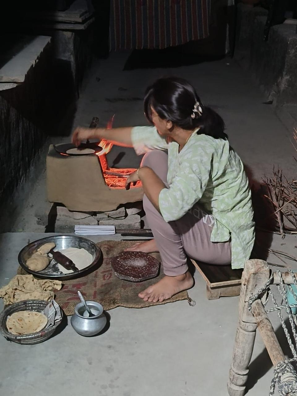 चूल्हे पर खाना बनाती अंजू यादव की पुरानी तस्वीर