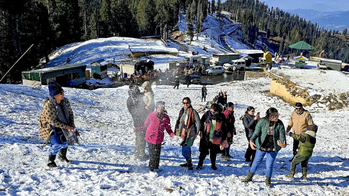 Visitors enjoy snowfall at Guldanda, near Bhaderwah, in Doda district of Jammu and Kashmir