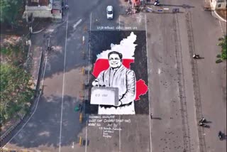 a-portrait-of-cm-siddaramaiah-holding-a-suitcase-made-from-rangoli