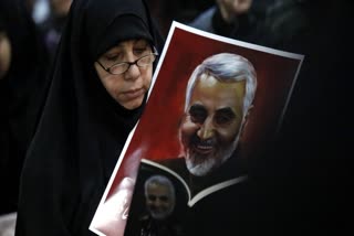 A supporter holds a portrait of Qassem Soleimani during a rally in the southern suburbs of Beirut