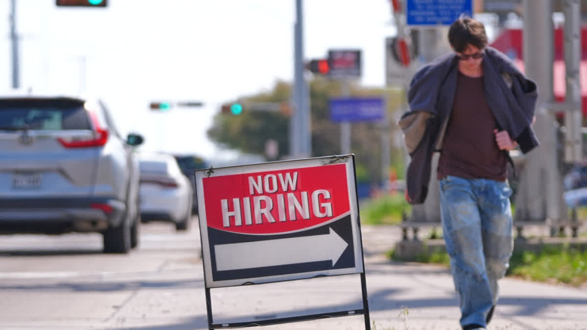 A now hiring sign sits on the side of the road in Garland, Texas, Monday, March 23, 2026.