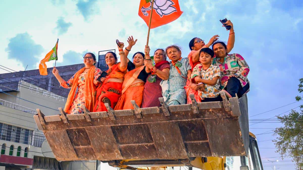 Women supporters of BJP celebrate the party's astounding victory in West Bengal atop a bulldozer.