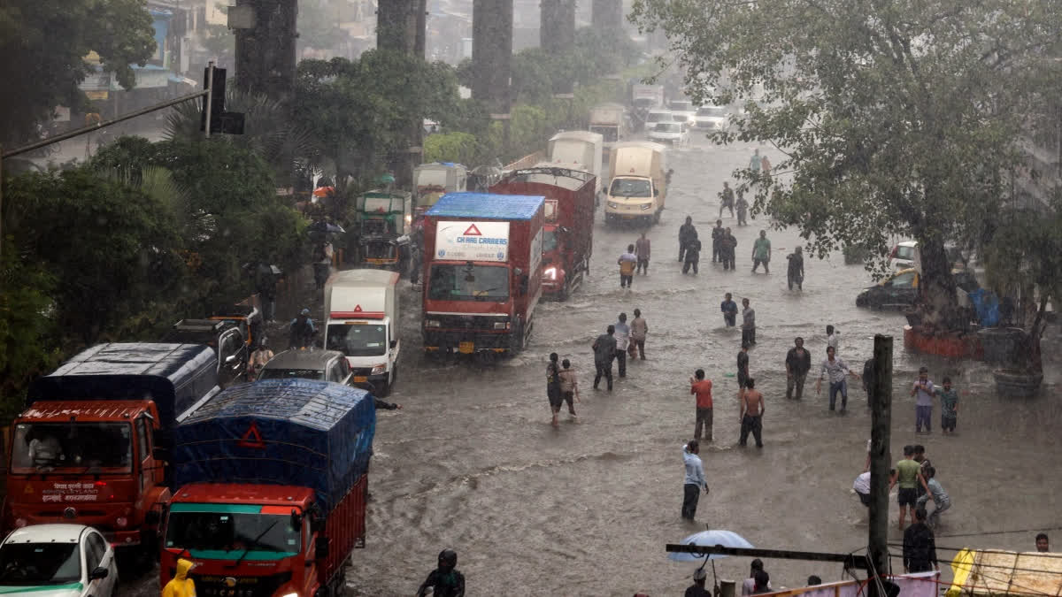 Heavy Rain Continues In Mumbai, IMD Issues Red Alert For More Showers Vehicles and people wade through a waterlogged road following heavy rainfall at Sakinaka, in Mumbai on Saturday.