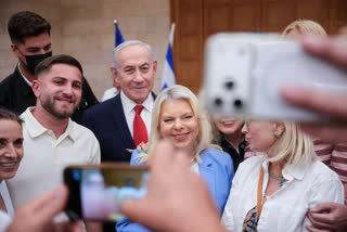 Israeli Prime Minister Benjamin Netanyahu, (C), and his wife, Sara, (C-R) arrive to cast their ballot at his party Likud's main polling station during primary elections ahead of Israel’s general election in October in Jerusalem on August 17,