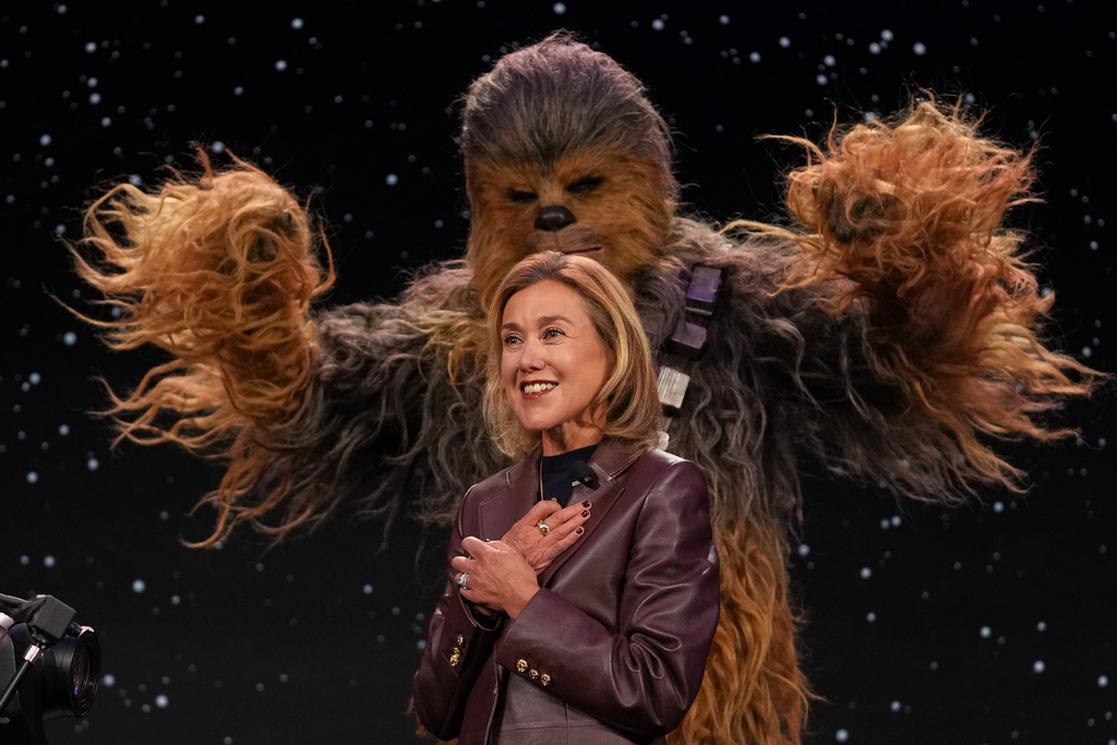 LEGO chief product and marketing officer and executive vice president Julia Goldin talks as a a Chewbacca stands behind her during an LEGO news conference ahead of the CES tech show Monday, Jan. 5, 2026, in Las Vegas.