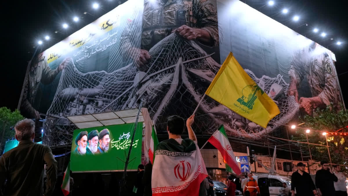 China's Top Envoy Meets With Iran's In Beijing As Trump Pauses US Effort In The Strait An Iranian demonstrator waves a flag of Lebanon's militant Hezbollah group under an anti-U.S. billboard depicting the American aircrafts into the Iranian armed forces fishing net with signs that read in Farsi: "The Strait of Hormuz will remain closed, The entire Persian Gulf is our hunting ground," during a pro-government gathering at Enqelab-e-Eslami, or Islamic Revolution, square in Tehran, Iran, Monday, May 4, 2026.