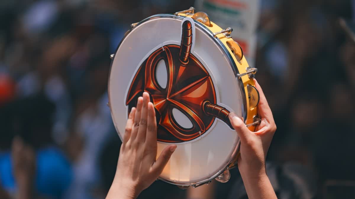 A Cockroach Janta Party (CJP) supporter plays a tambourine, also known as 'dafli', during a protest demanding the resignation of Union Education Minister Dharmendra Pradhan over alleged examination-related lapses, at the Jantar Mantar, in New Delhi, Saturday