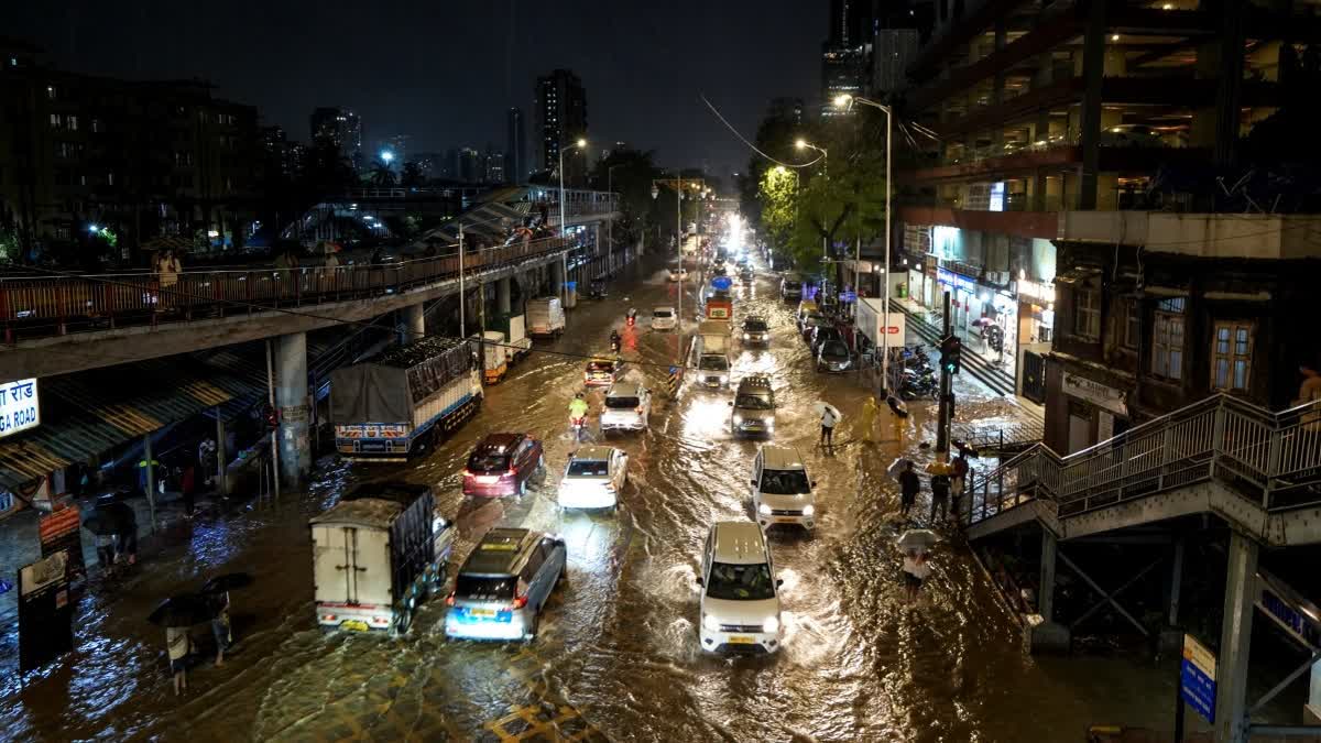 Vehicles pass through a waterlogged road in Mumbai, Maharashtra