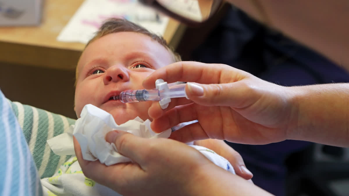 Baby being administered an oral vaccine