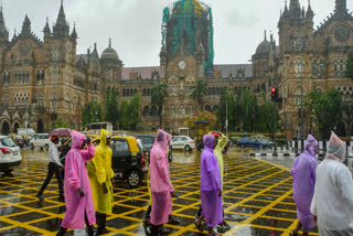 People stroll amid rain, near Chhatrapati Shivaji Maharaj Terminus (CSMT) in Mumbai, on Monday.
