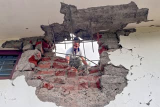 A man looks through a damaged portion of a house after heavy firing and shelling by Pakistan military overnight across the Line of Control and International Border, at Mendhar area of Poonch district, Jammu and Kashmir, Wednesday, May 7, 2025